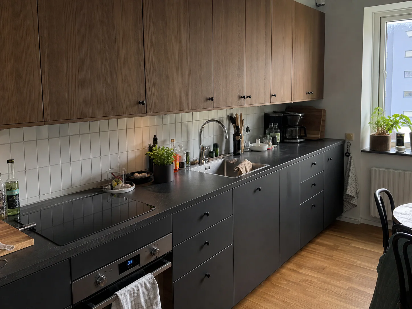 Färdigt kök med mörka underskåp och överskåp i trä
