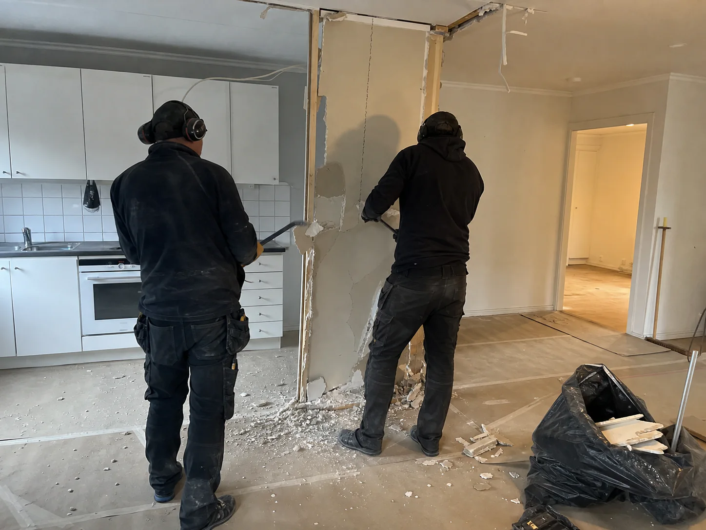 Två hantverkare utför kontrollerad innerväggsrivning